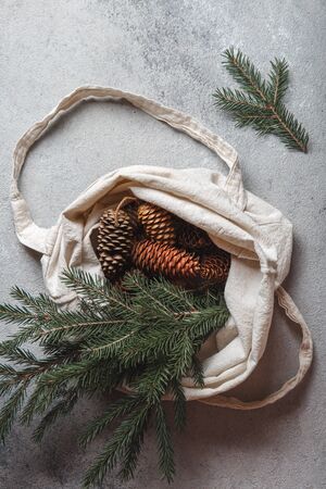 Zero waste Christmas concept. Natural Chirsmas decoration, pine cones and branches in linen bag. Flat lay, top viewの写真素材