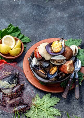 Famous traditional dish of the south of Chile and the Chiloe archipelago - Curanto Kuranto.  Different seafood and meat cooked in a pit on the coals under the ground.の写真素材