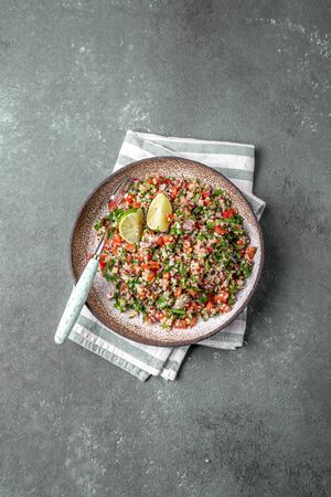 Traditional Lebanese salad tabouli tabule with quinoa, herbs, tomatoes, mint and lemon.の写真素材