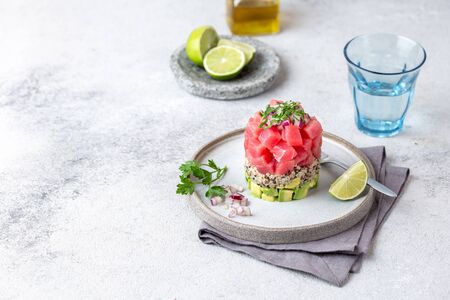 Tuna tartare tartar with avocado and quinoa. gourmet presentation with culinary ring on wite plate.の写真素材