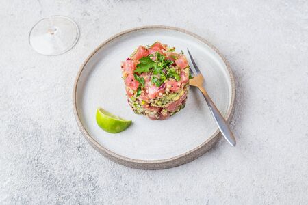 Tuna tartare tartar with avocado and quinoa. gourmet presentation with culinary ring on wite plate.の写真素材