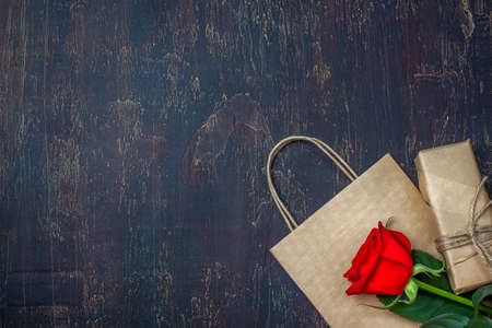 Gift or present box wrapped in kraft paper and rose Flat lay styling. Copy space for text.の写真素材