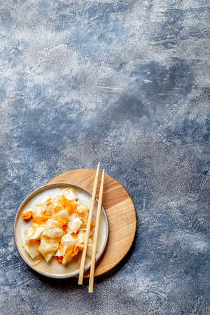 Corean kimchi. Fermented spisy cabbage on gray plate, gray backgroundの写真素材