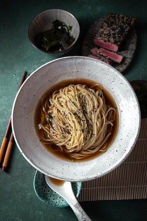 Japanese ramen. Asian soup with noodles ramen, miso, fried tuna steak and seaweed algae