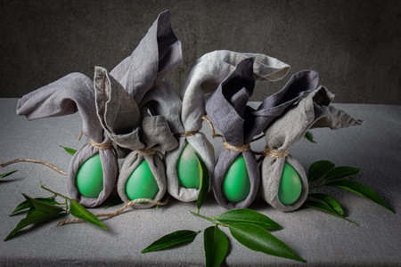 Festive Easter table setting. Funny Easter bunny made of egg and linen napkin on plate. gray background.の写真素材