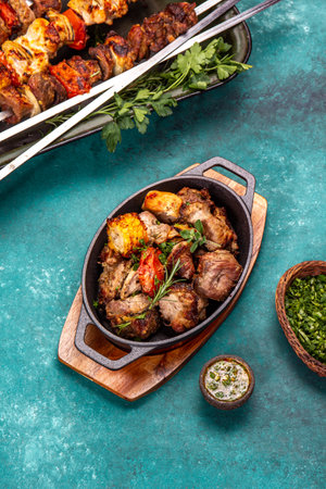 Bbq grilled meat - pork, chicken and vegetable on cast iron pan. Grilled skewers on blue wooden background. Top viewの写真素材