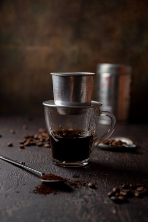 Preparation of Vietnamese coffe with aluminum cofe filer on dark backgroundの写真素材