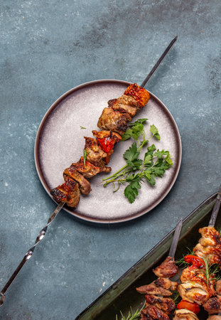 Bbq grilled meat pork and vegetable skewers on gray plate . Top view, flat lay, gray backgroundの写真素材