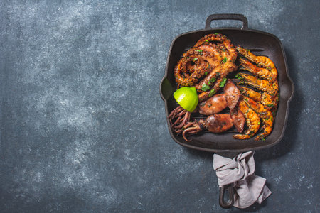 Grilled spimps, squids and octopus in cast iron grill panの写真素材