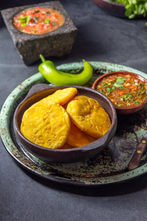Sopaipilla. Latin American food. Traditional chilean homemade pumpkin sopaipillas with typical salsas - chancho en piedra tomato sauce in stone mortar and spicy pebreの写真素材