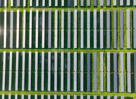 Solar panels on field in summer, aerial drone view
