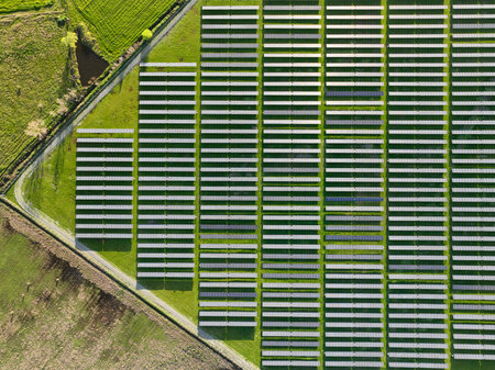 Solar panels on field in summer, aerial drone view