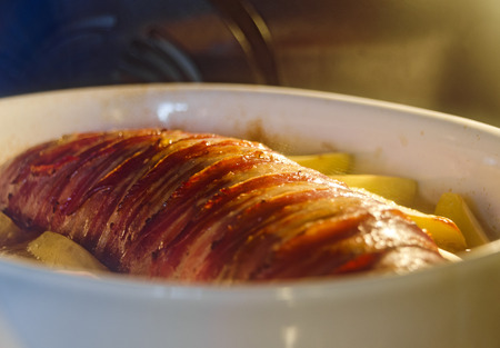 roast wrapped around with crispy bacon in the ovenの写真素材