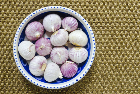 tubers of solo garlic in a porcelain bowlの写真素材