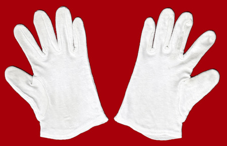 a pair of white cotton gloves on red backgroundの写真素材