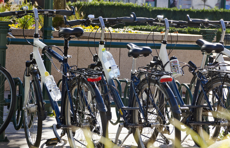 Bikes with water bottles in sunshine on a cycle rack