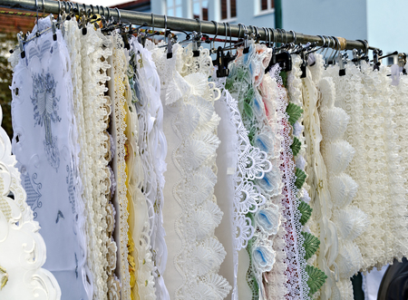 Clothes hanger with lace doily of a pedlar  on a traditional outdoor commercial fair (Simonimarket)...