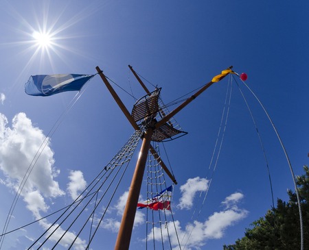 flagpole shaped like a ship's mast before glorious  blue sky with bright sun, Zingst, Germanyの写真素材