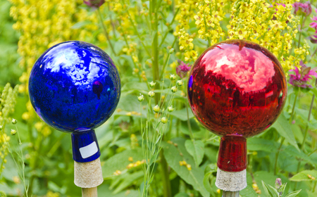 colorful glossy glass bowls as decoration in a gardenの写真素材