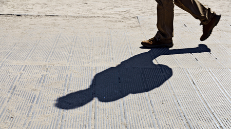 Feet and shadow of a walker on a sandy beach, Zingst, Germanyの写真素材