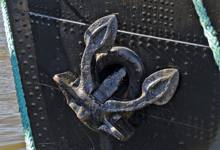 old anchor at the bow of a riveted hulk of an old iron ship at Hamburg, Germanyの写真素材