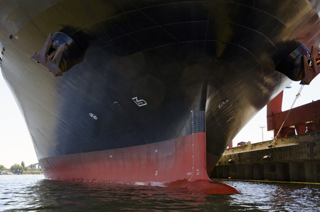 hull of a container ship with bulbous bow at the harbour of Hamburg, Germanyのeditorial素材