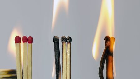 the same three matches in different conditions: original, ignited and burned offの写真素材