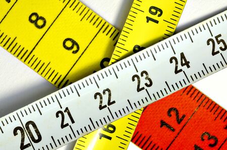 Near view of crossing red, yellow and white cloth tape measures