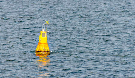 Yellow navigation mark with solar panels labeled Roadstead on the wavy Baltic sea