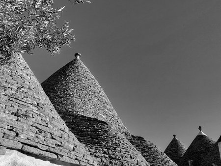 Black and white photo of historic Trulli houses with stone tile cone-shaped rooftops in Alberobello, Puglia, Southern Italy â UNESCO World Heritage Site architectureの写真素材