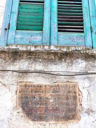 Window Shutters with Antique Inscription on Building Facade in Puglia, Italyの写真素材