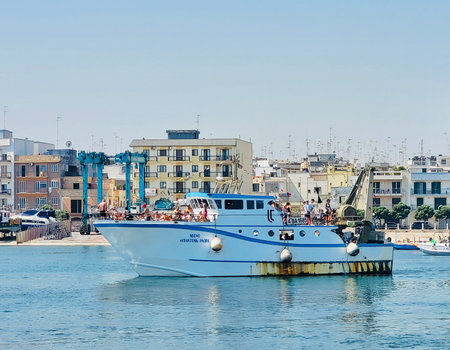 Vibrant fishing boats floating in the calm harbor of Mola di Bari, Puglia, Southern Italy. Bright Mediterranean colorsの写真素材