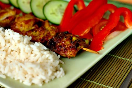 Meat on a stick with rice and vegetablesの写真素材
