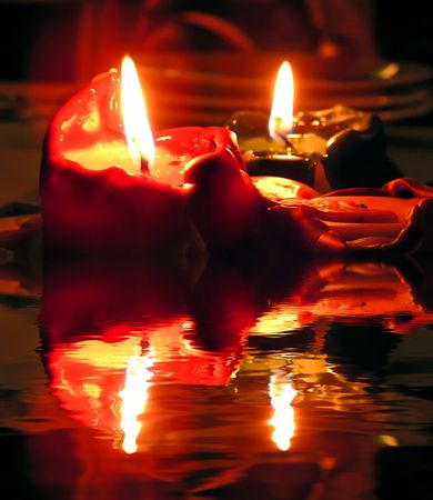 Burning candles and their reflection on waterの写真素材