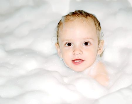 Little girl in the bath with foam