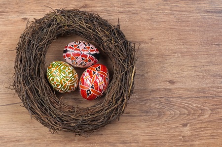 The painted eggs in the nest on wooden backgroundの写真素材