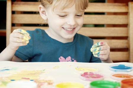 Little girl painting colors on handの写真素材