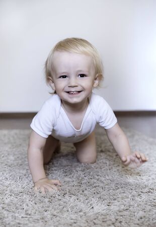 The boy - toddler crawling on the carpet and laughingの写真素材