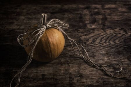 The Orange pumpkin with ribbon on wooden backgroundの写真素材