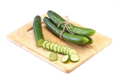 Cucumber and slices isolated over the wooden board の写真素材