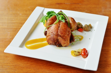 Roasted spring chicken  with broccoli, tomatoes and other garnishes. の写真素材