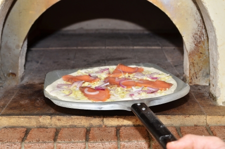 Pizza on  spatula ready to go into oven        の写真素材