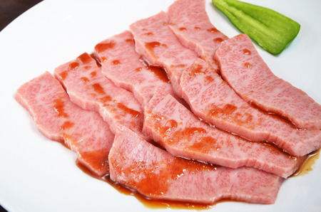 Thinly sliced beef on white plateの写真素材