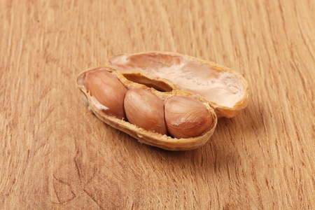 Peanut in shells on wood background