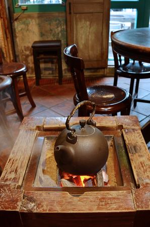 Old kettle put on a fireplace for hot drinkingの写真素材