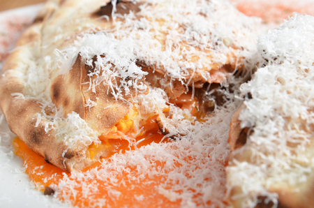 Closeup of italian pizza calzone on white plateの写真素材