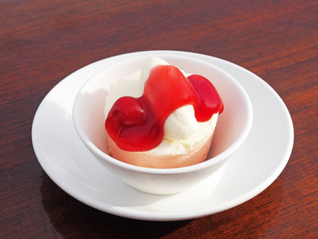 Strawberry mousse cake in white bowl on wooden tableの写真素材