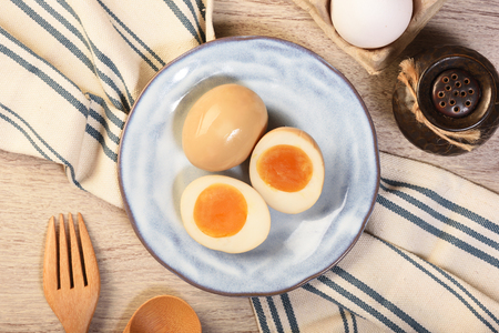 Plate of soft boiled eggs on wooden tableの写真素材