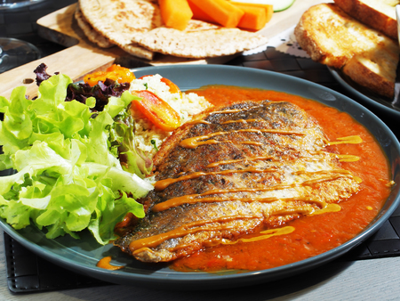 Fried sea bass with vegetables and sauce