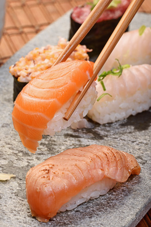 Chopsticks picking up salmon sushiの写真素材